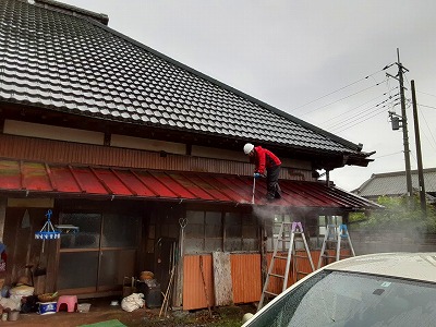 瓦棒屋根板金の高圧洗浄している様子